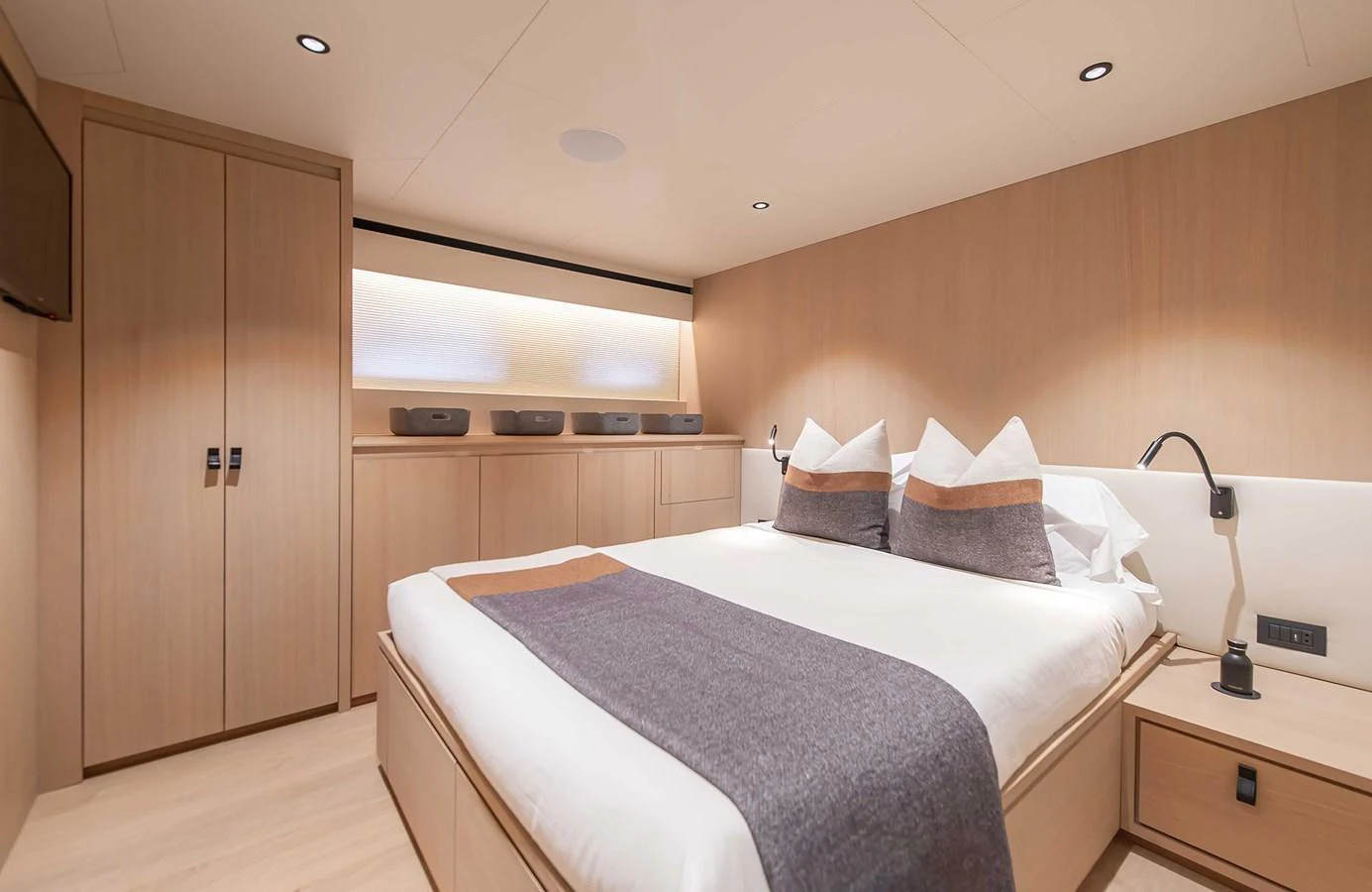 The stateroom features a spacious bed with elegant bedding and ample storage space. aboard 27 CROSSOVER Yacht for Sale