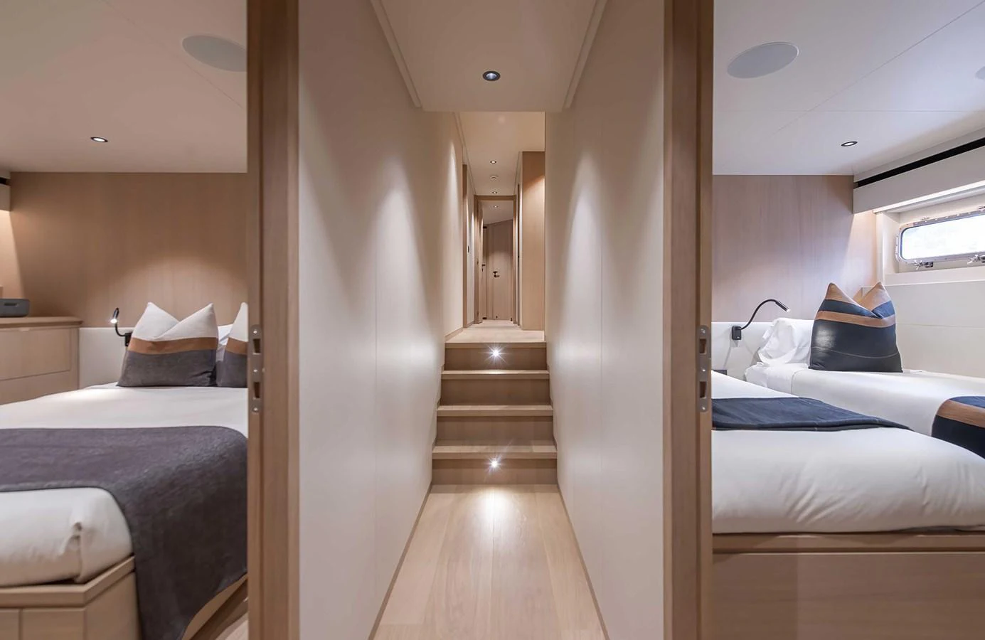 The image showcases the inviting guest cabins with a central hallway and warm lighting. aboard 27 CROSSOVER Yacht for Sale