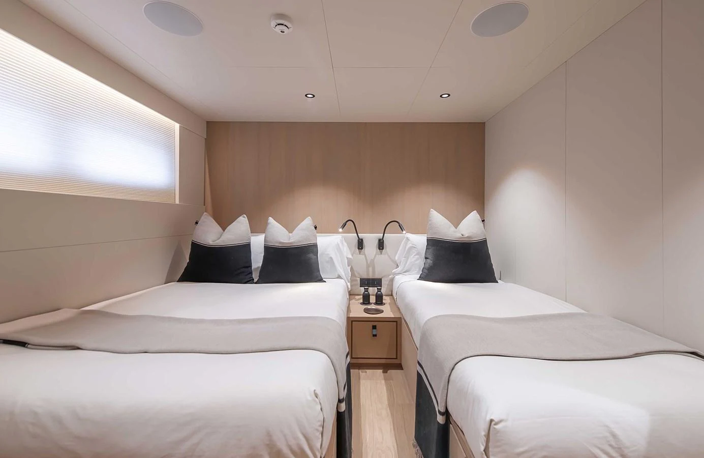 The guest stateroom features twin beds with a modern and minimalist design. aboard 27 CROSSOVER Yacht for Sale