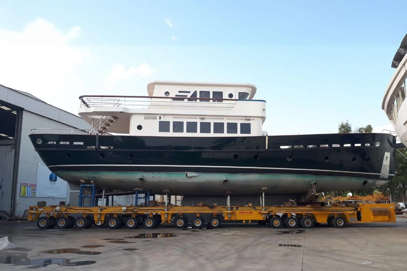 A yacht is seen on a transport platform, showcasing its sleek design and multi-level structure. aboard SVETLANA Yacht for Sale
