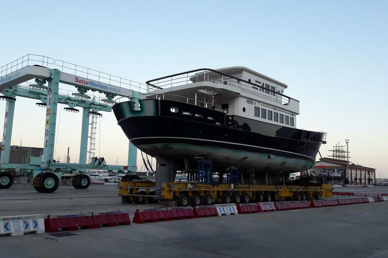 A yacht is positioned on a transport platform at a marina, ready for launch or maintenance. aboard SVETLANA Yacht for Sale