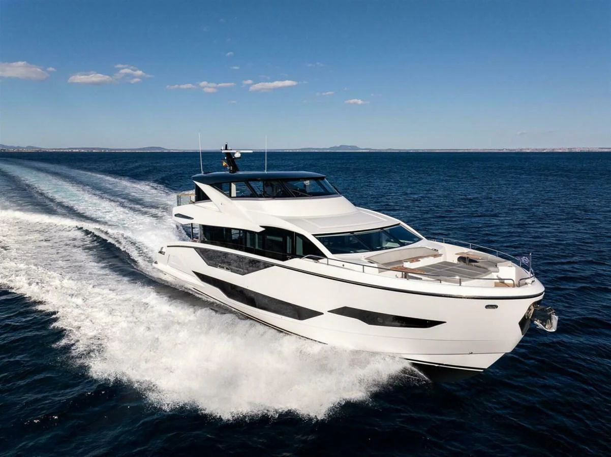 A sleek, modern yacht cruises swiftly through the open sea under a clear blue sky. aboard 90 OCEAN ENCLOSED Yacht for Sale