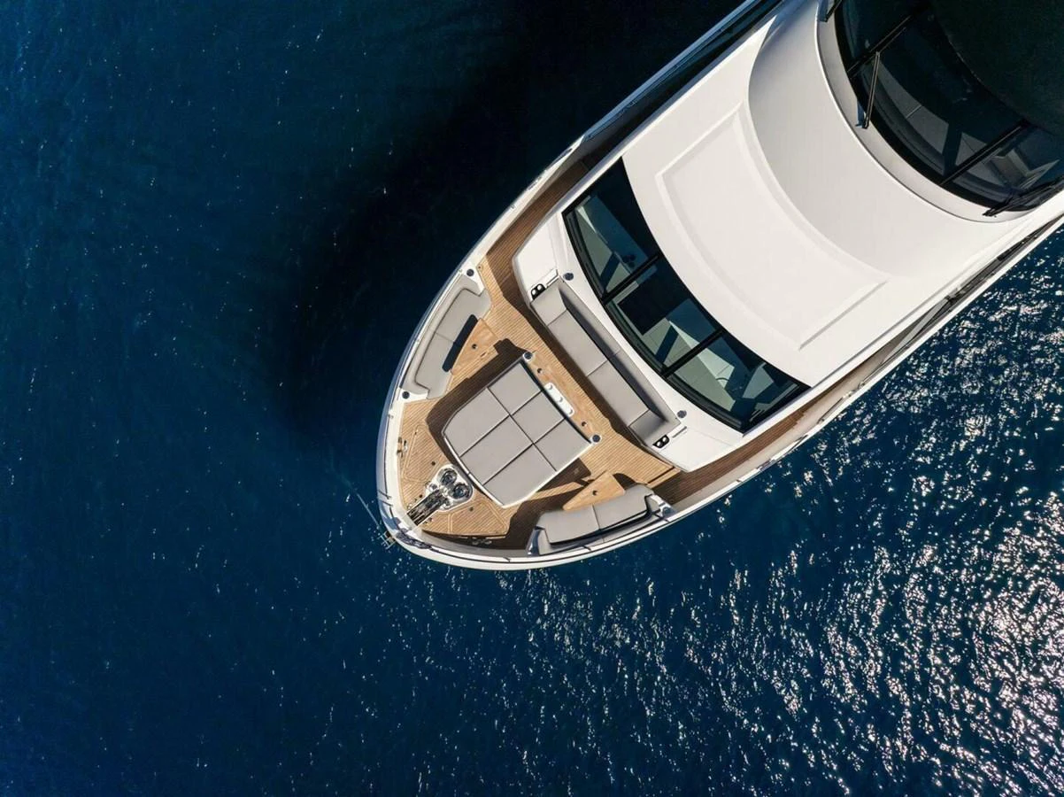 An aerial view of the yacht's bow showcasing its sleek design and spacious sunbathing area. aboard 90 OCEAN ENCLOSED Yacht for Sale