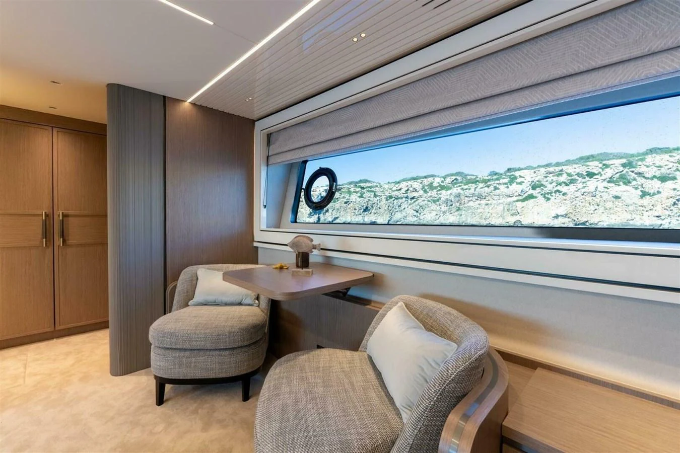 A serene interior seating area with a large window offering a scenic view. aboard 90 OCEAN ENCLOSED Yacht for Sale