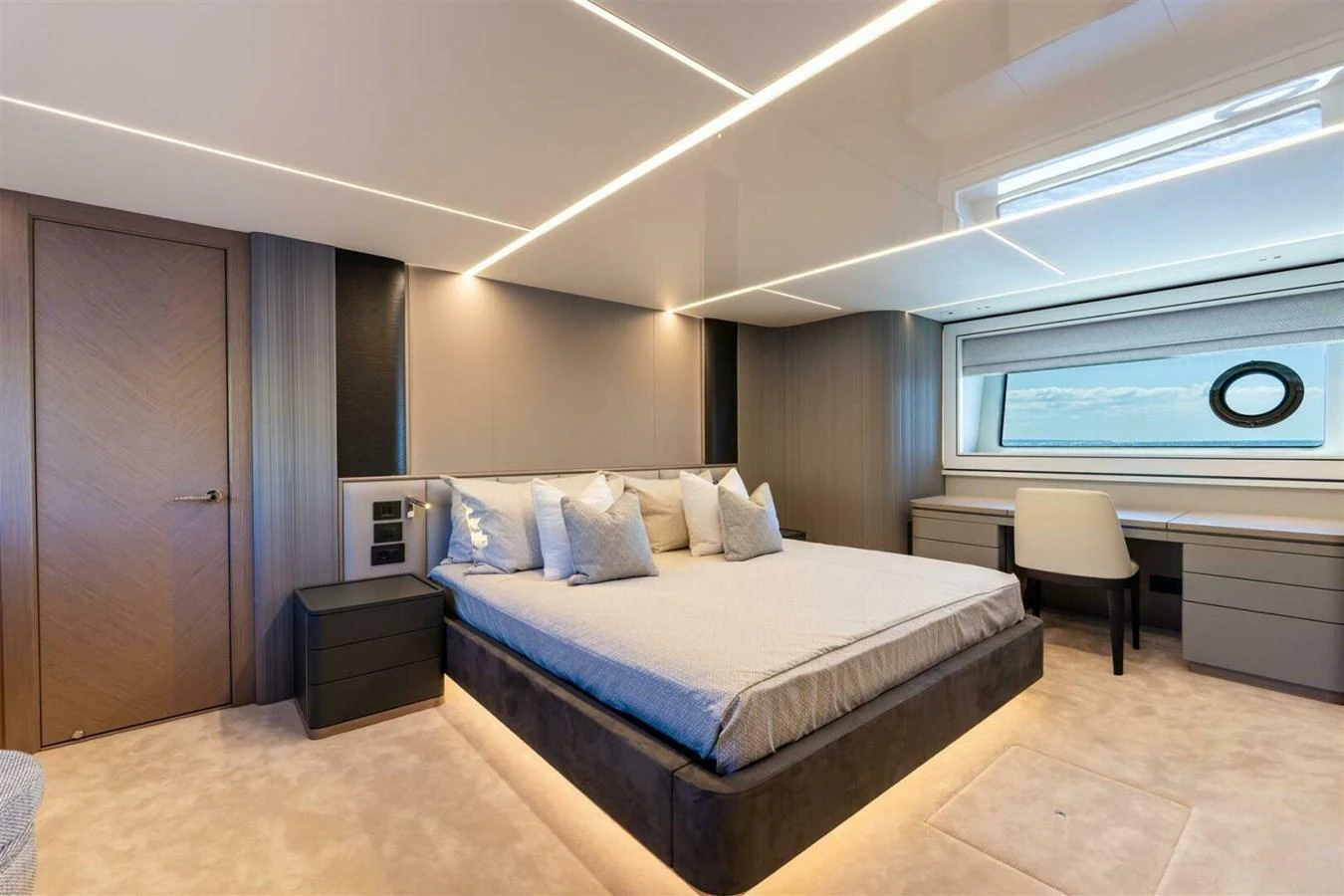 The master stateroom features a luxurious bed with modern lighting and a large window offering a serene view. aboard 90 OCEAN ENCLOSED Yacht for Sale