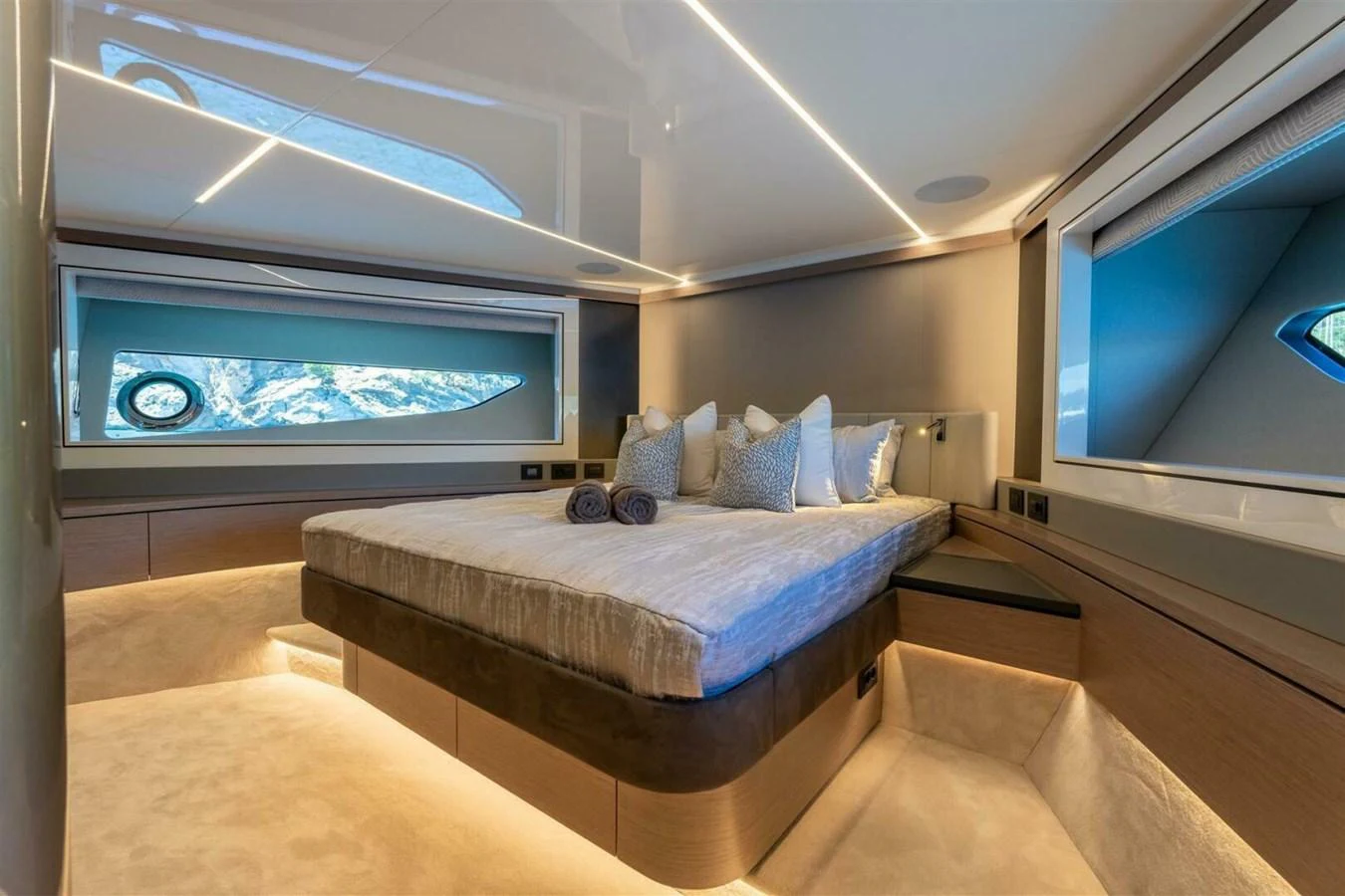 The stateroom features a luxurious bed with ample natural light from large windows. aboard 90 OCEAN ENCLOSED Yacht for Sale