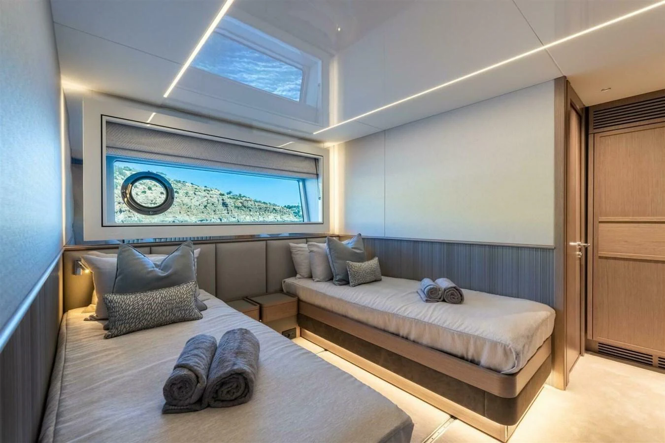 The guest cabin features twin beds with plush linens and a large window offering scenic views. aboard 90 OCEAN ENCLOSED Yacht for Sale