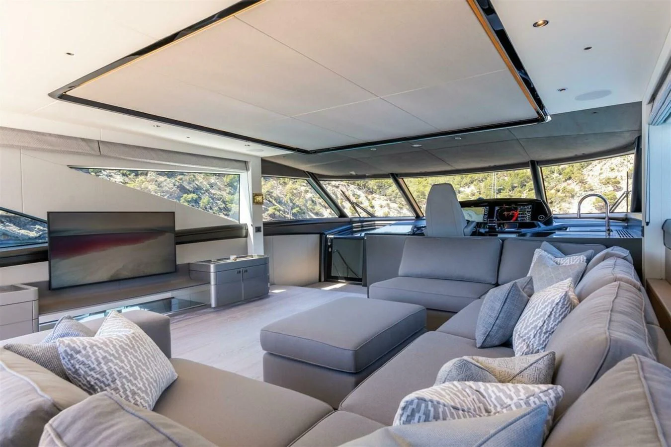 The salon features a spacious and modern seating area with panoramic windows offering stunning views. aboard 90 OCEAN ENCLOSED Yacht for Sale