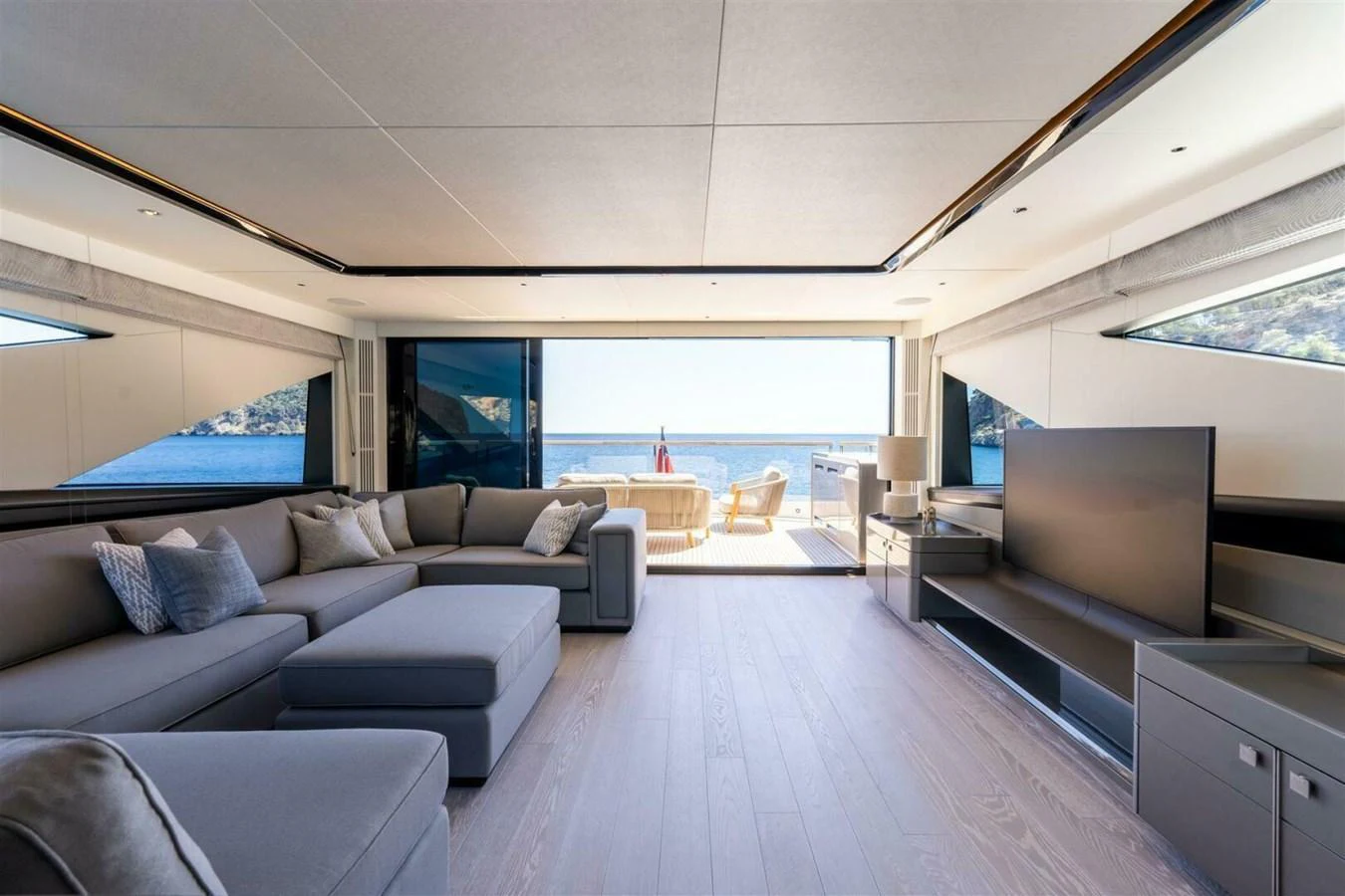 The spacious salon offers a luxurious and comfortable seating area with a stunning view of the sea through large windows. aboard 90 OCEAN ENCLOSED Yacht for Sale