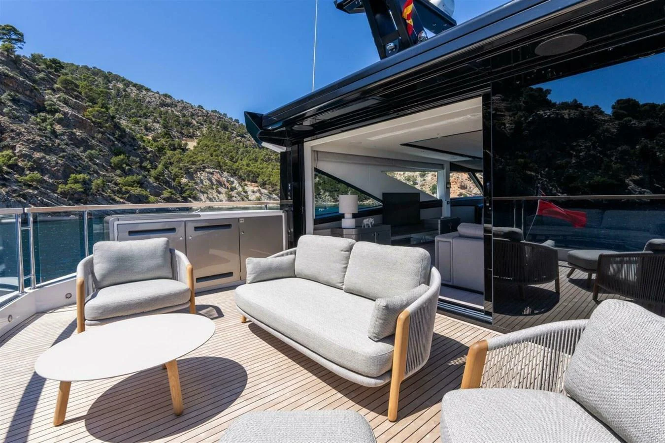 The aft deck features comfortable seating with a scenic view of the surrounding landscape. aboard 90 OCEAN ENCLOSED Yacht for Sale
