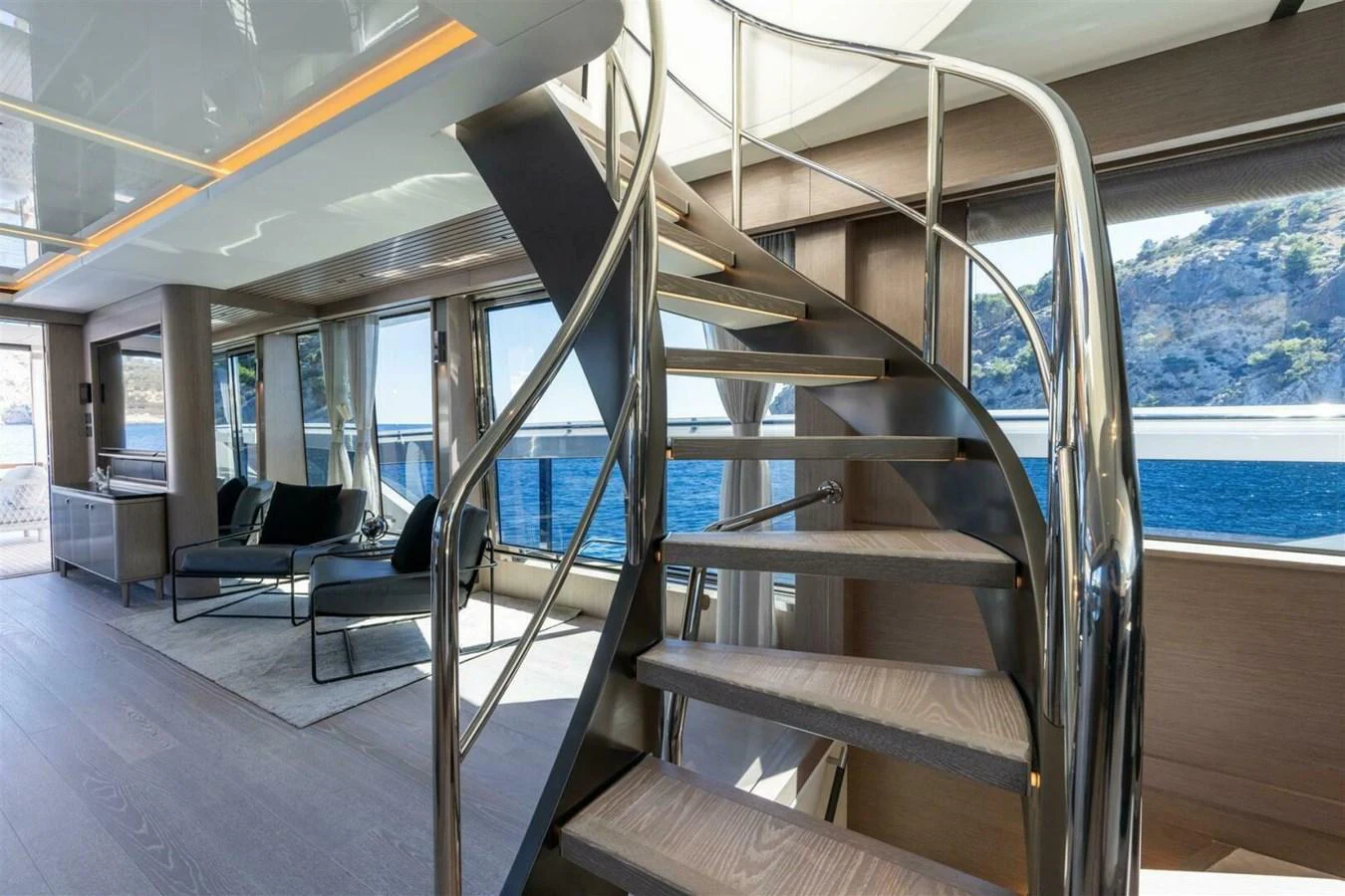 The salon features a modern spiral staircase with panoramic windows offering stunning sea views. aboard 90 OCEAN ENCLOSED Yacht for Sale
