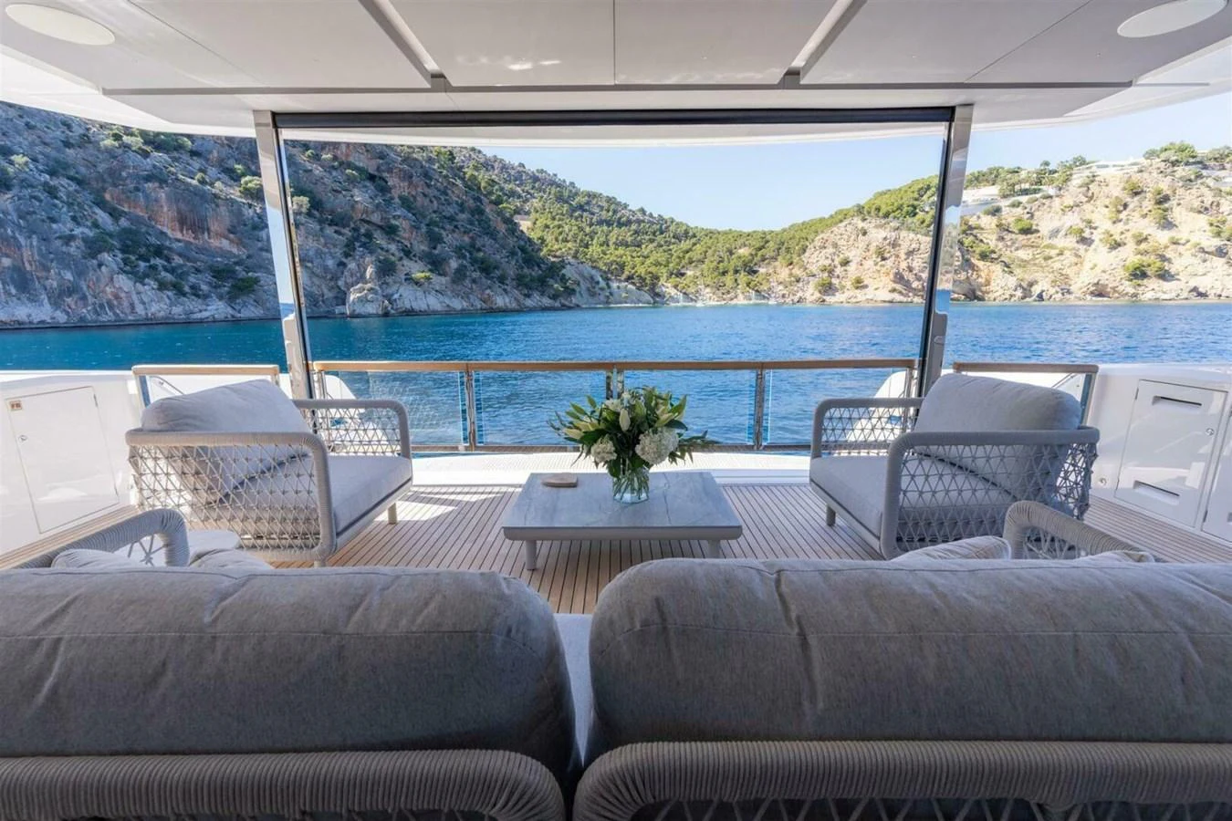The aft deck offers a serene seating area with a stunning view of the surrounding waters and landscape. aboard 90 OCEAN ENCLOSED Yacht for Sale