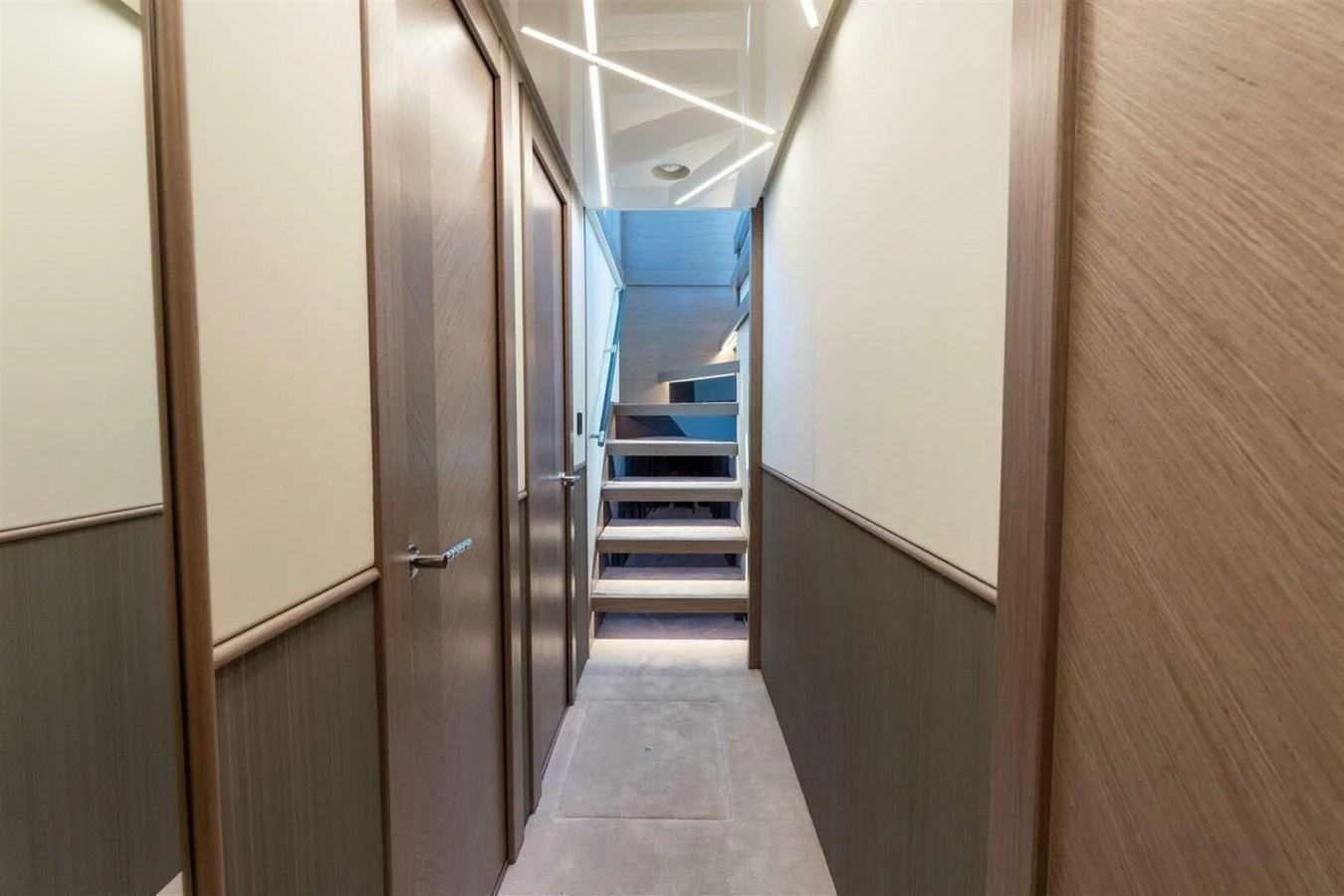 A modern hallway with wooden accents and a staircase leading to the upper deck. aboard 90 OCEAN ENCLOSED Yacht for Sale