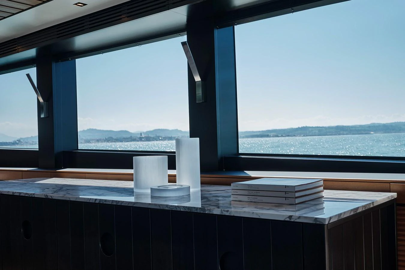 A luxurious interior space with large windows offering a stunning sea view. aboard WALLYWHY200 Yacht for Sale