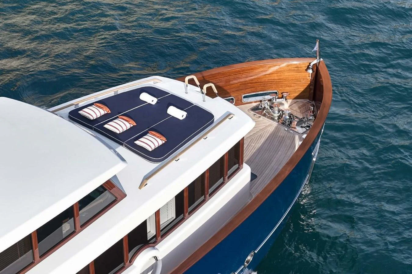The yacht's bow showcases elegant woodwork and sleek design, floating gracefully on the water. aboard PICCHIOTTI 24 Yacht for Sale
