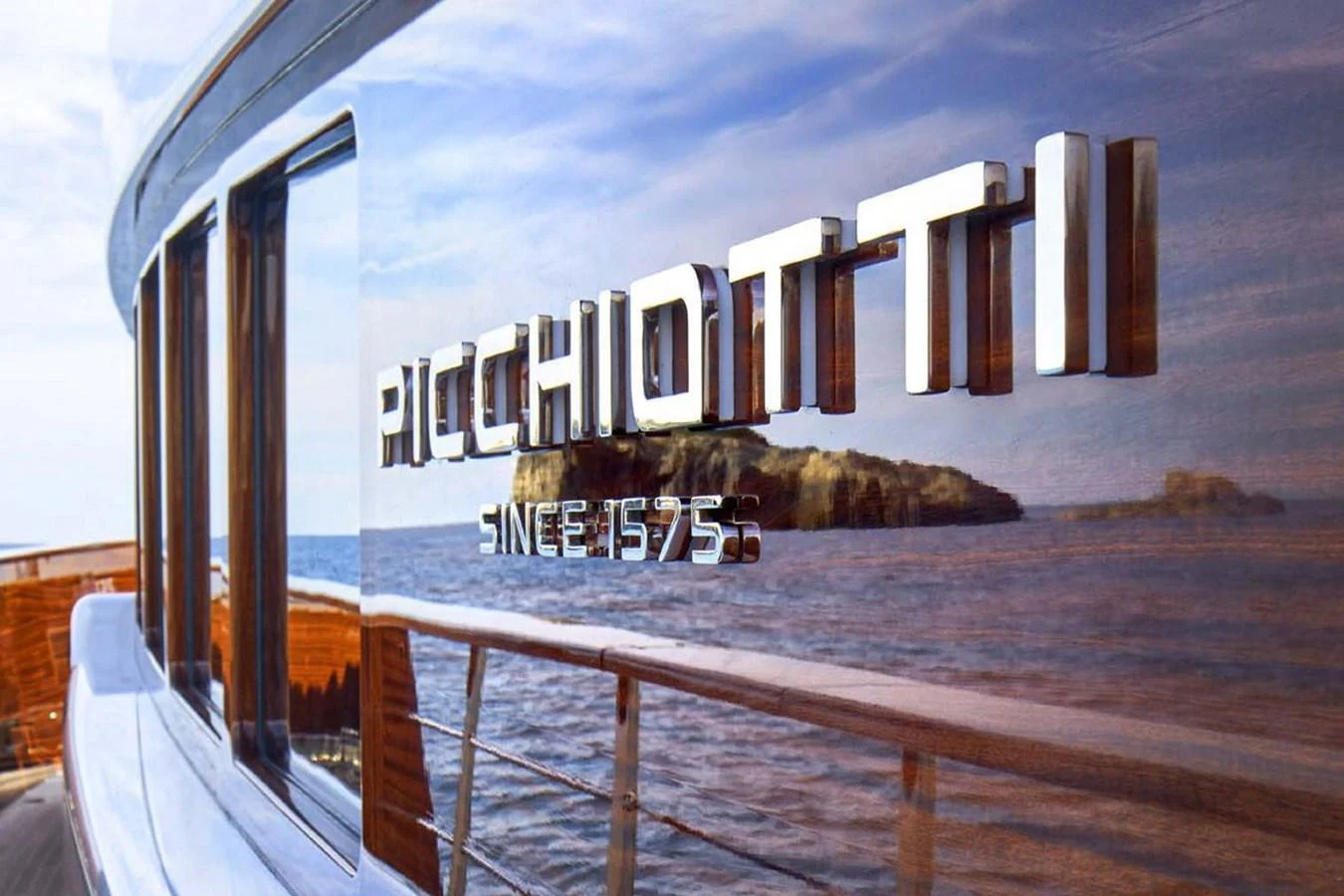 A close-up view of the yacht's polished exterior showcasing the brand name and the scenic ocean backdrop. aboard PICCHIOTTI 24 Yacht for Sale
