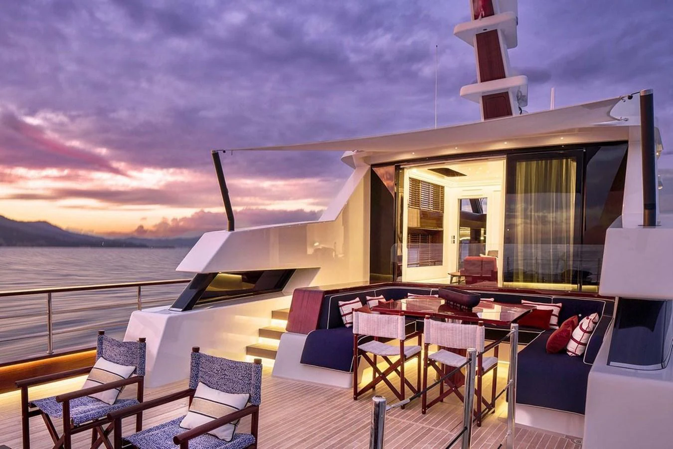 The yacht's aft deck offers a luxurious outdoor seating area with a stunning view of the sunset over the water. aboard PICCHIOTTI 24 Yacht for Sale