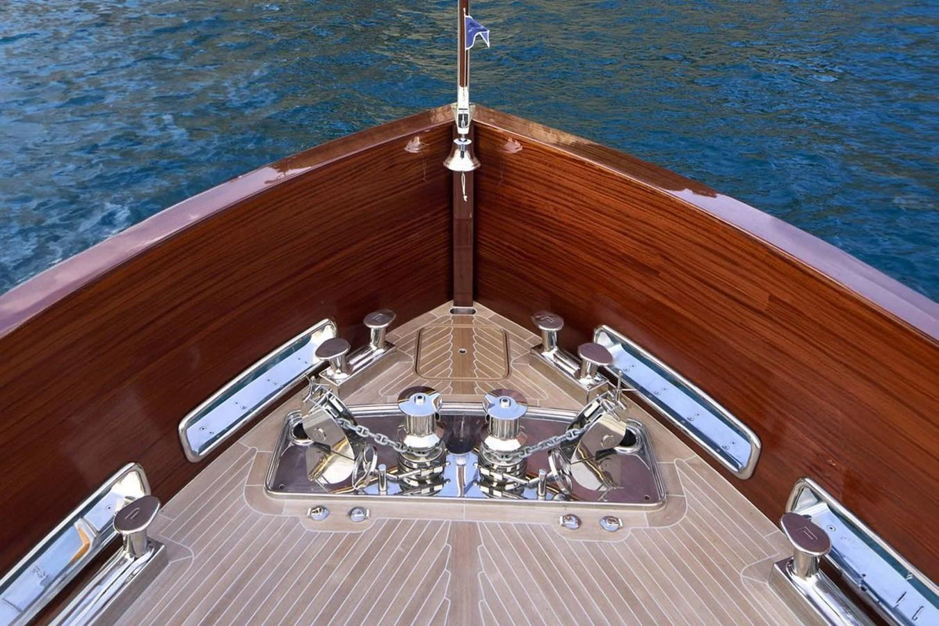 The image showcases the polished bow area of a yacht with intricate woodwork and metal fittings. aboard PICCHIOTTI 24 Yacht for Sale