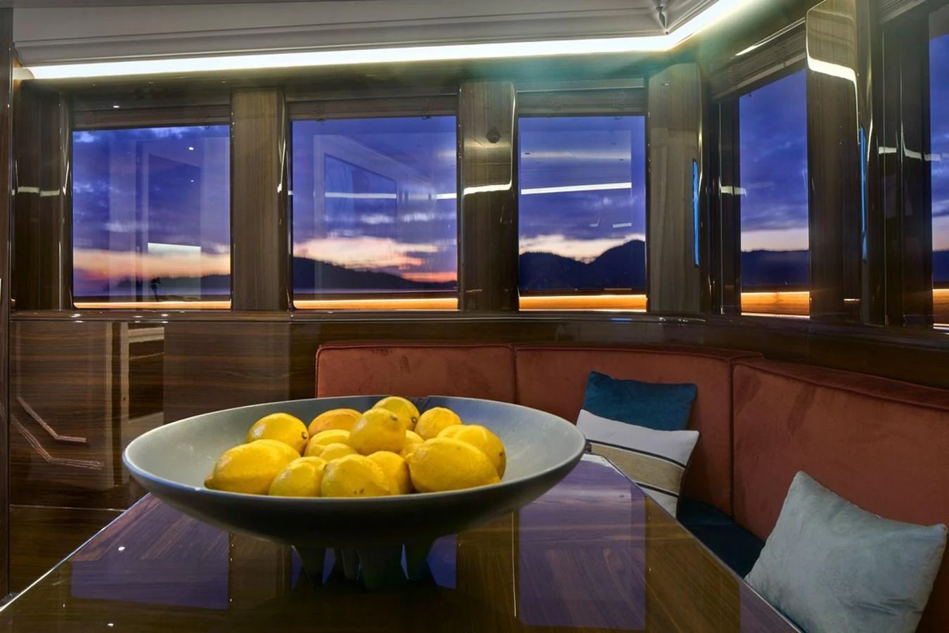 The yacht's interior features a cozy seating area with large windows offering stunning sunset views. aboard PICCHIOTTI 24 Yacht for Sale