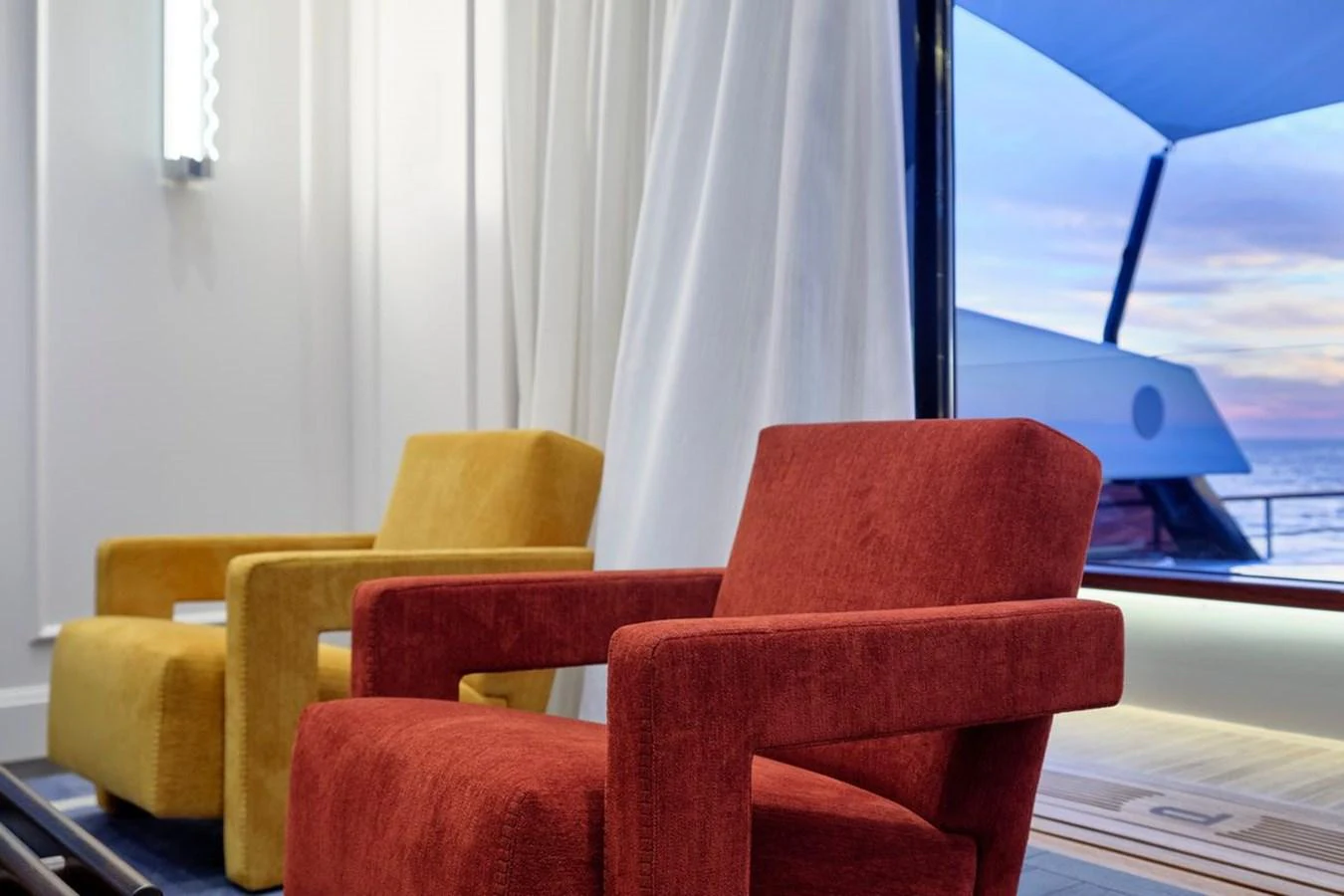 The interior features modern, colorful seating with a view of the ocean through large windows. aboard PICCHIOTTI 24 Yacht for Sale