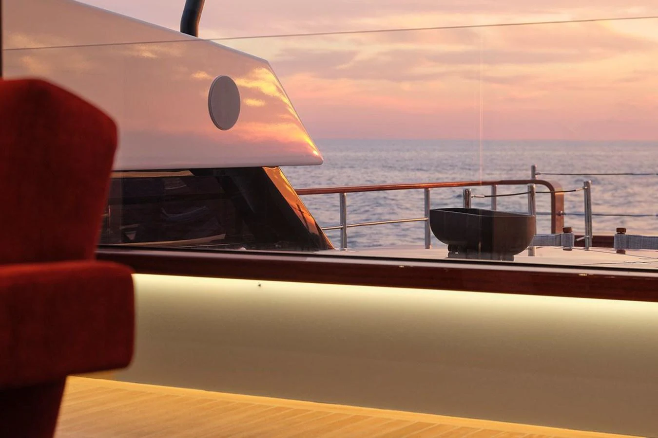 A serene view from the yacht's interior, looking out onto the deck and the ocean at sunset. aboard PICCHIOTTI 24 Yacht for Sale
