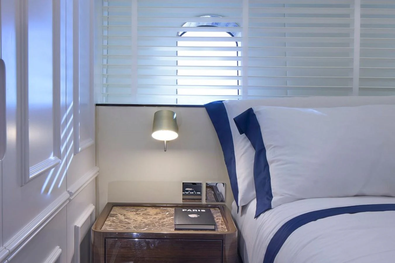The stateroom features a cozy bed with elegant linens and a bedside table with a reading lamp. aboard PICCHIOTTI 24 Yacht for Sale