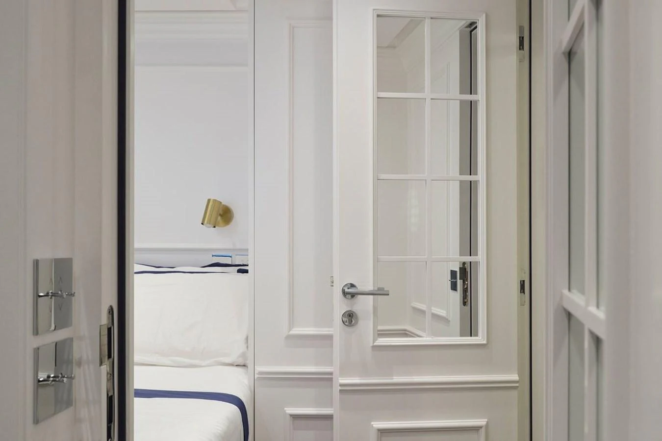 A pristine white hallway leads to a cozy stateroom with elegant decor. aboard PICCHIOTTI 24 Yacht for Sale