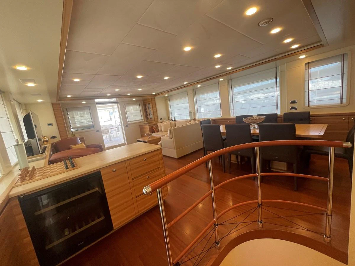 The spacious salon features elegant wood finishes, ample seating, and large windows for natural light. aboard STELLA DEL NORD Yacht for Sale