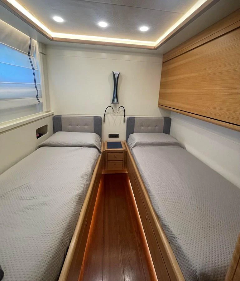 A cozy twin stateroom with modern lighting and wooden accents. aboard STELLA DEL NORD Yacht for Sale