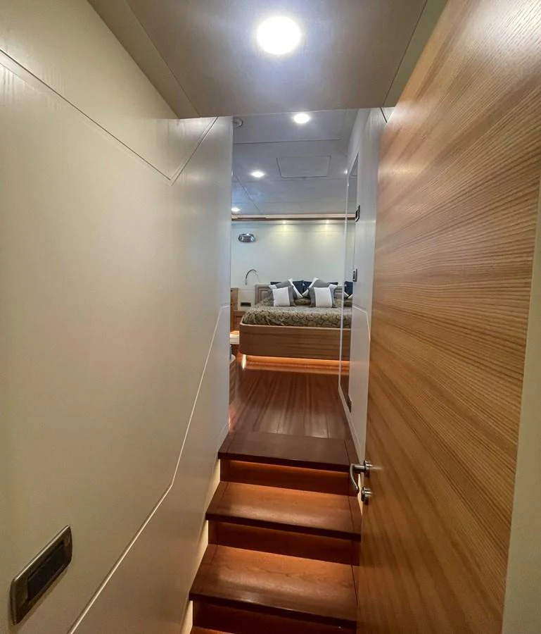 A cozy entrance leads to a luxurious stateroom with plush bedding and elegant lighting. aboard STELLA DEL NORD Yacht for Sale