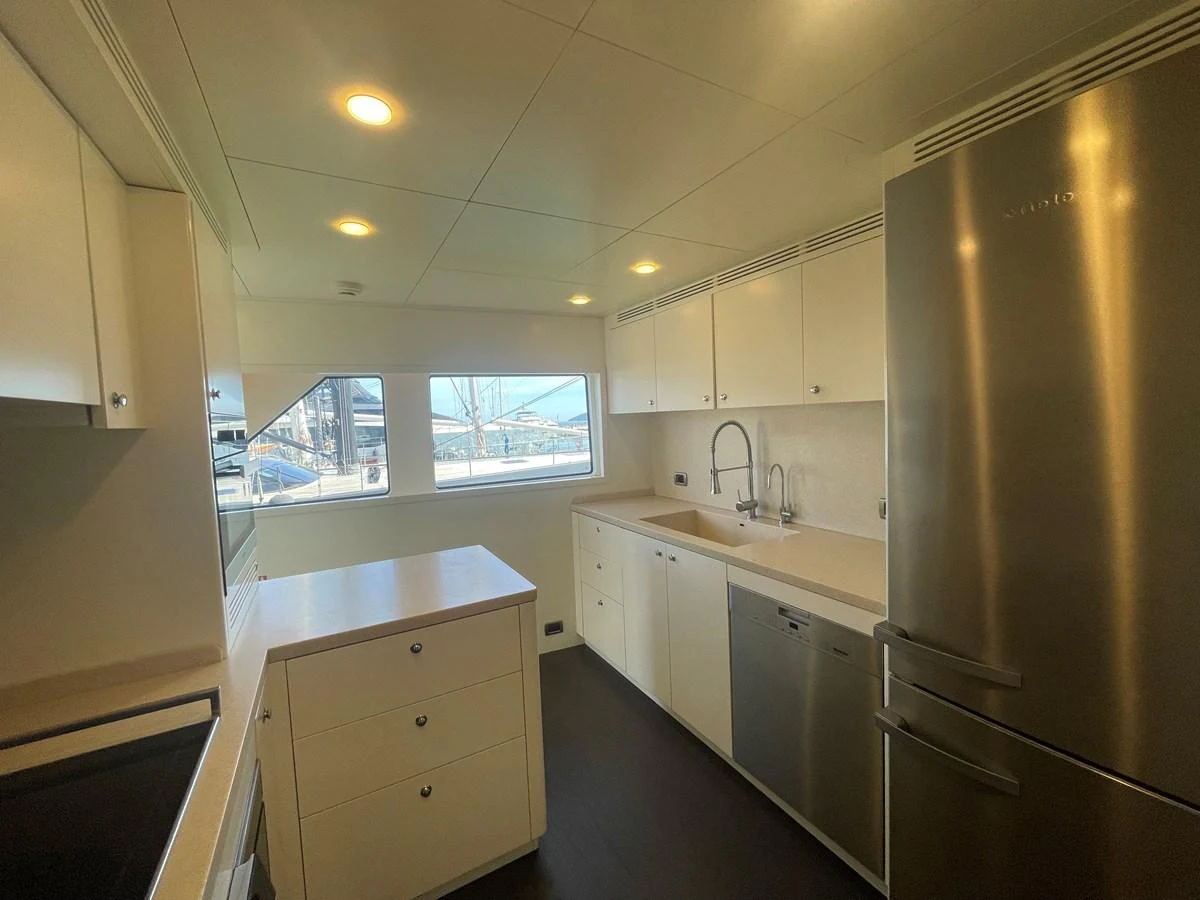 The yacht's galley features modern appliances and ample counter space, illuminated by natural light from large windows. aboard STELLA DEL NORD Yacht for Sale