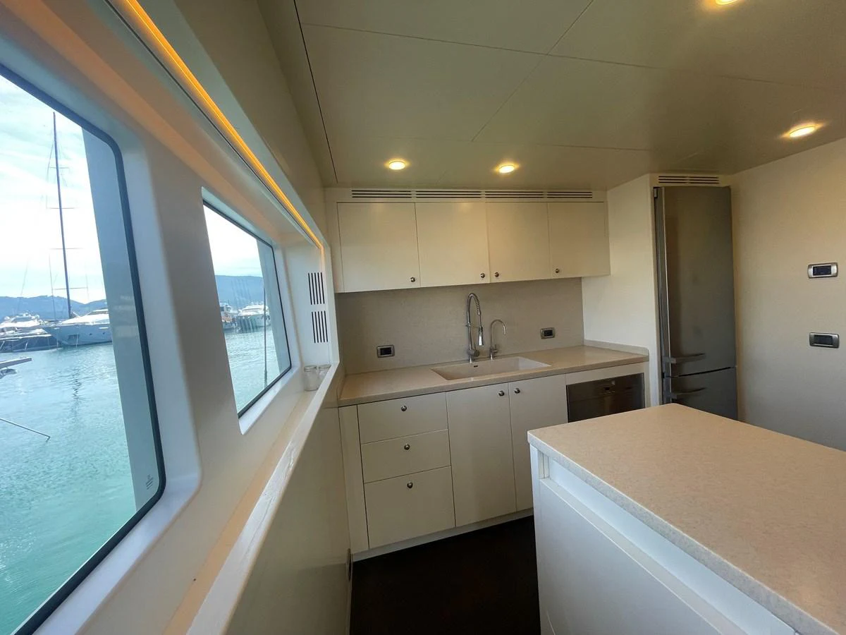 The yacht's galley features modern cabinetry and a sleek countertop with ample natural light from the large window. aboard STELLA DEL NORD Yacht for Sale