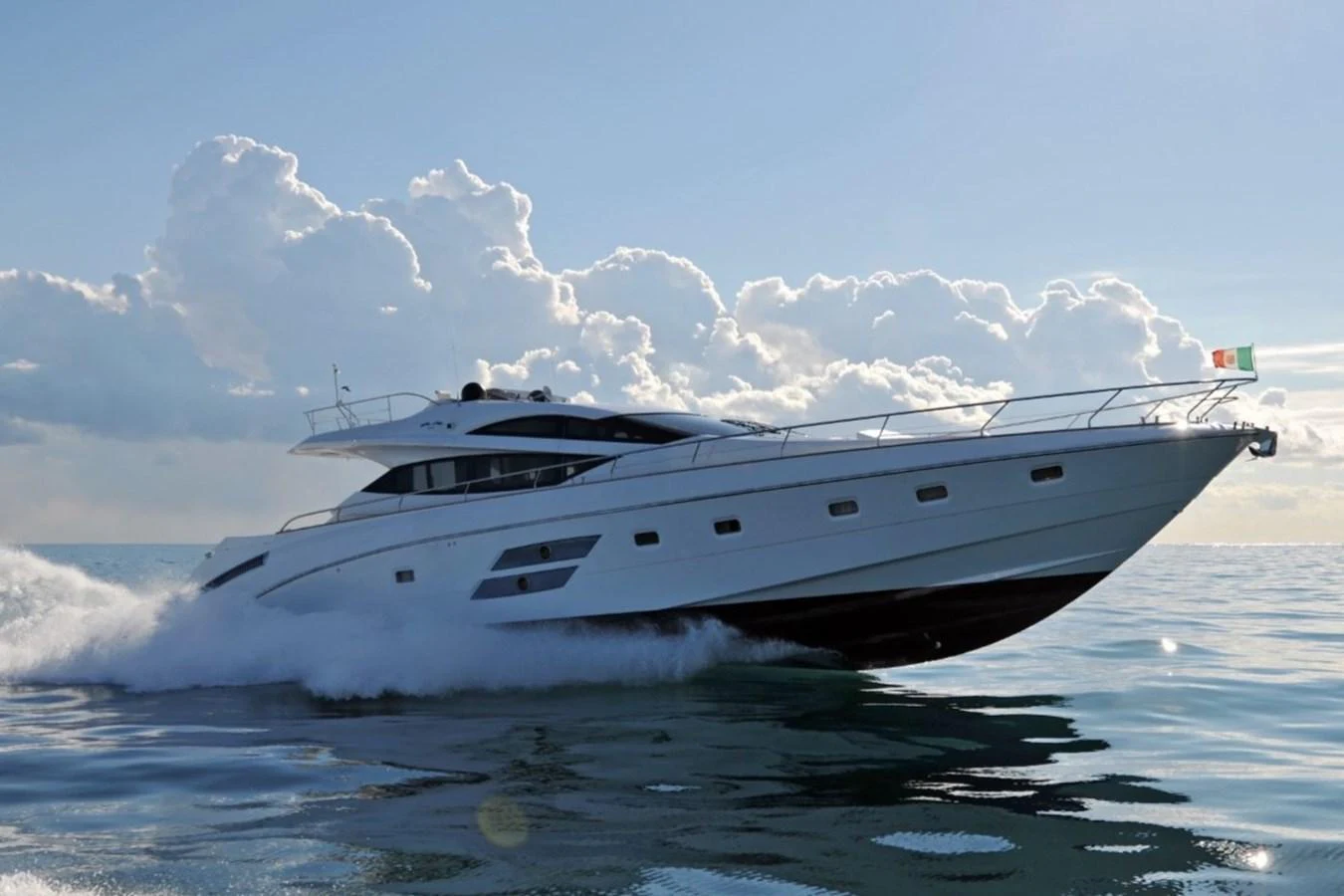 A sleek and modern yacht glides swiftly across the water under a bright sky. aboard SARNICO GRANDE HULL #3 Yacht for Sale