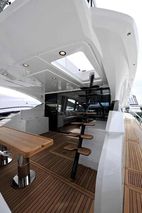 The aft deck features a sleek design with a wooden table and modern staircase leading to the upper deck. aboard SARNICO GRANDE HULL #3 Yacht for Sale