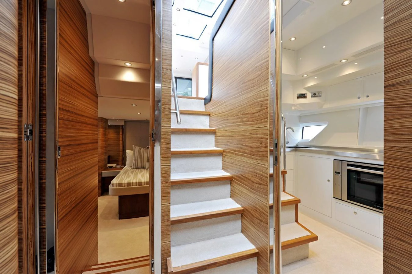 The yacht's interior features a modern staircase leading to a well-lit galley and cozy living quarters. aboard SARNICO GRANDE HULL #3 Yacht for Sale