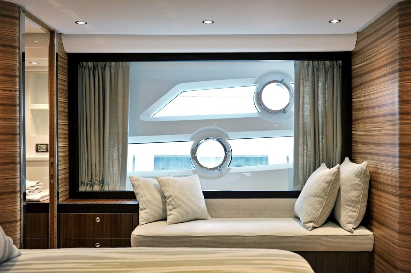 The stateroom features a cozy seating area with a large window offering a view of the sea. aboard SARNICO GRANDE HULL #3 Yacht for Sale