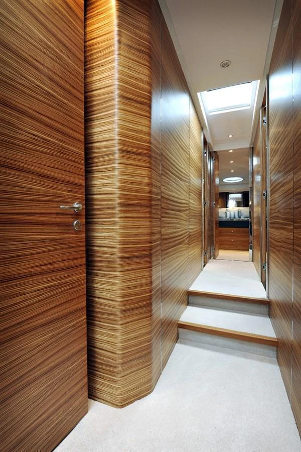 A sleek hallway with wooden paneling and a skylight, leading to a well-lit area. aboard SARNICO GRANDE HULL #3 Yacht for Sale