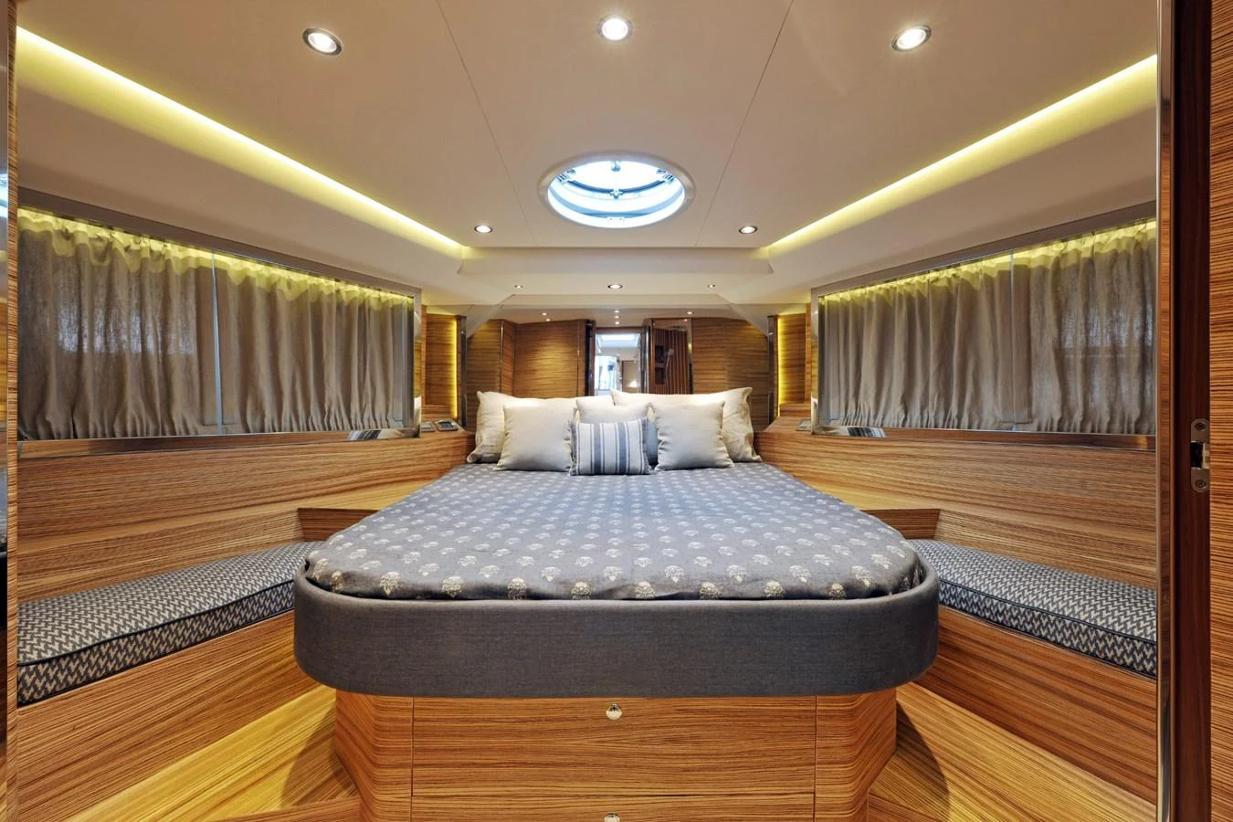 The master stateroom features a luxurious bed with elegant wood paneling and ambient lighting. aboard SARNICO GRANDE HULL #3 Yacht for Sale