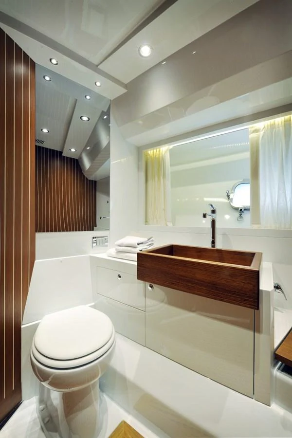 A sleek and modern yacht bathroom with elegant wood accents and contemporary fixtures. aboard SARNICO GRANDE HULL #3 Yacht for Sale