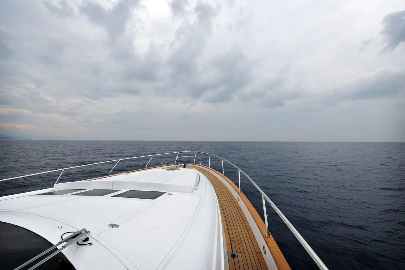 The foredeck of the yacht offers a serene view of the open sea under a cloudy sky. aboard SARNICO GRANDE HULL #3 Yacht for Sale
