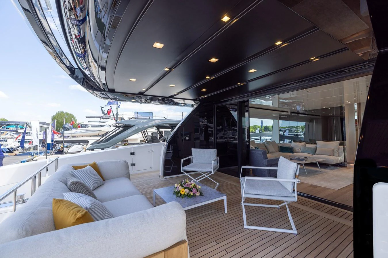 The aft deck features a comfortable seating area with modern furnishings and a view of the marina. aboard SX76 #144 Yacht for Sale