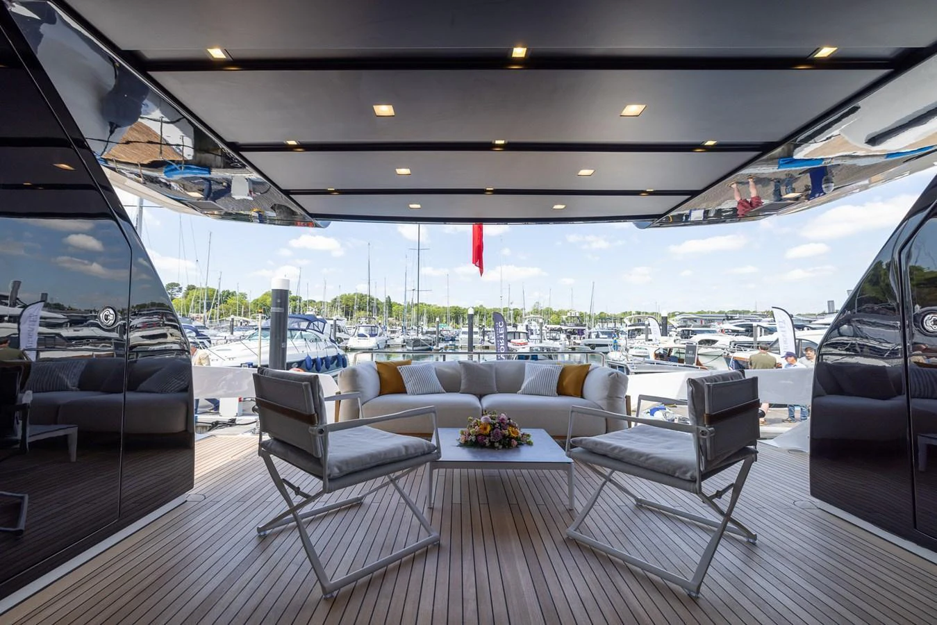 The aft deck features a comfortable seating area with a view of the marina. aboard SX76 #144 Yacht for Sale