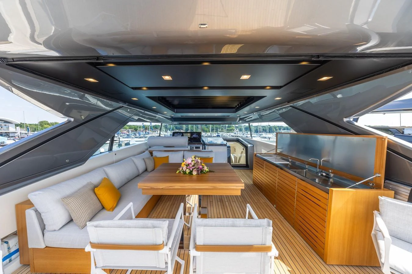The aft deck features a spacious seating area with a dining table and a well-equipped bar. aboard SX76 #144 Yacht for Sale
