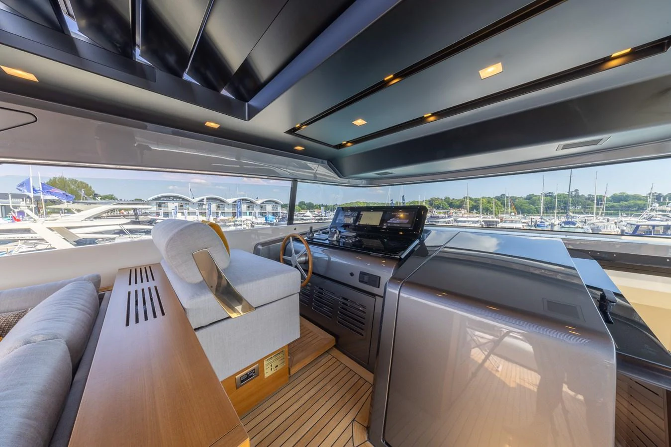 The helm station offers a sleek and modern design with panoramic views of the marina. aboard SX76 #144 Yacht for Sale