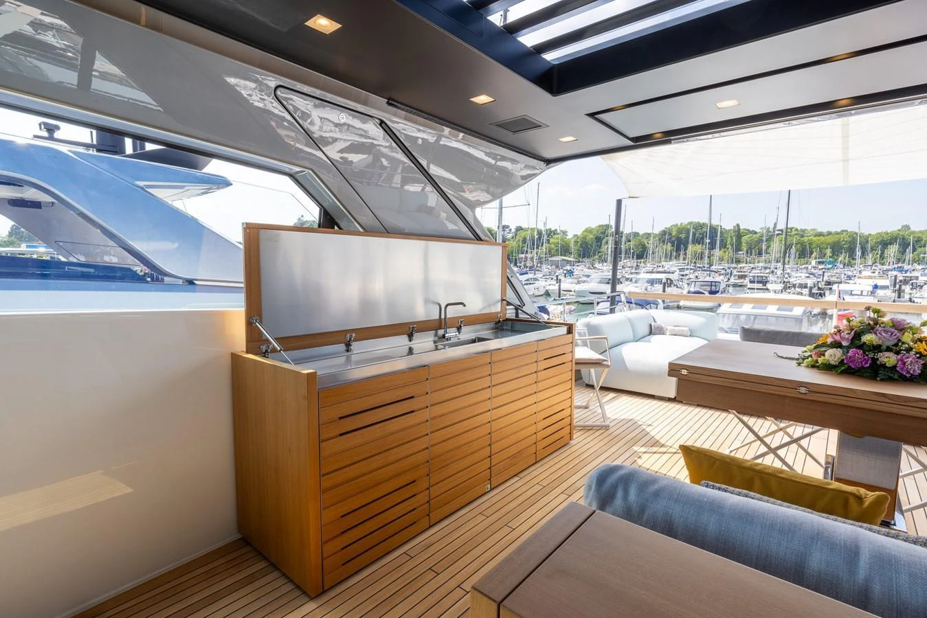 The aft deck features a sleek, modern design with a built-in bar and comfortable seating area. aboard SX76 #144 Yacht for Sale