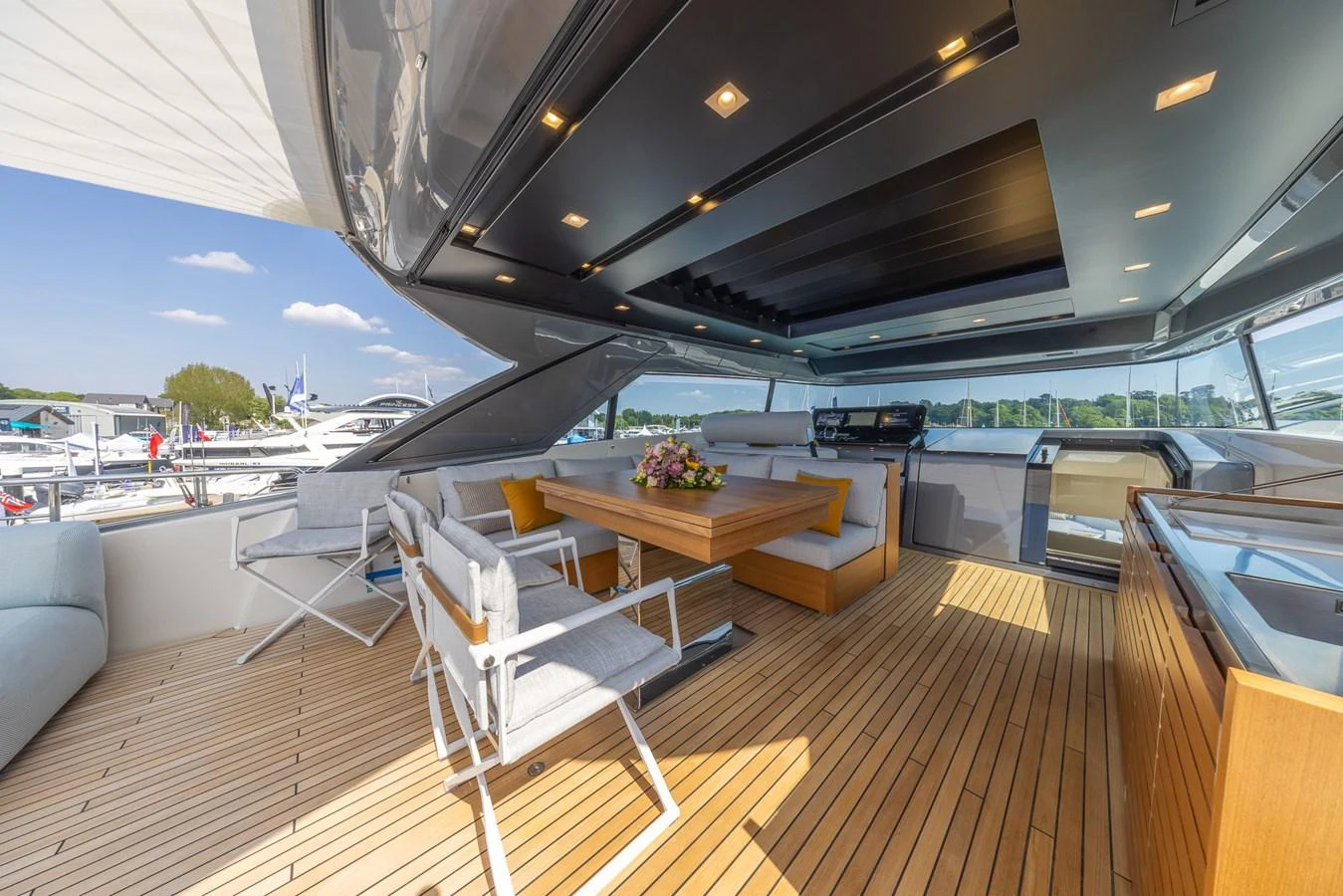 The aft deck features a spacious seating area with a dining table, perfect for alfresco dining and relaxation. aboard SX76 #144 Yacht for Sale
