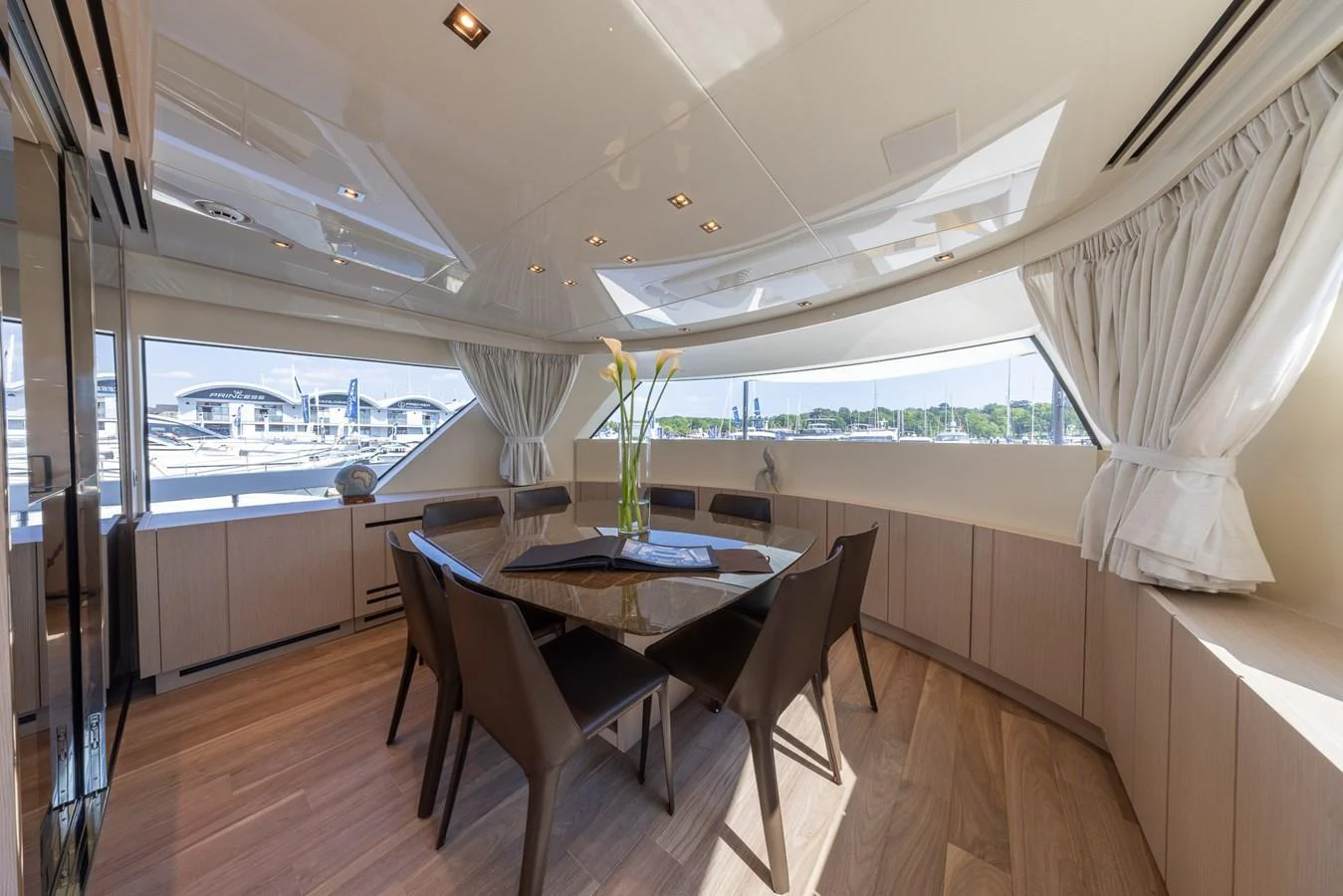 The yacht's dining area features a sleek, modern design with ample natural light and elegant furnishings. aboard SX76 #144 Yacht for Sale