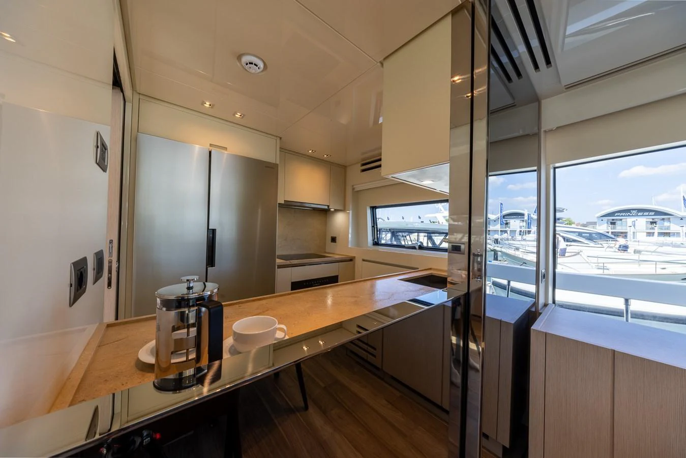 The yacht's galley features modern appliances and ample natural light through large windows. aboard SX76 #144 Yacht for Sale