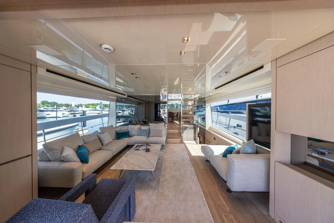 The salon features a spacious and elegantly designed seating area with large windows offering panoramic views. aboard SX76 #144 Yacht for Sale