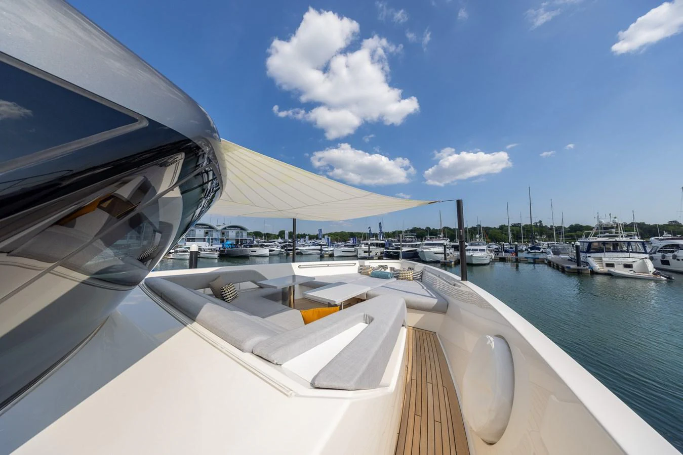 The yacht's foredeck features a spacious lounging area with comfortable seating and a sunshade, perfect for relaxation. aboard SX76 #144 Yacht for Sale